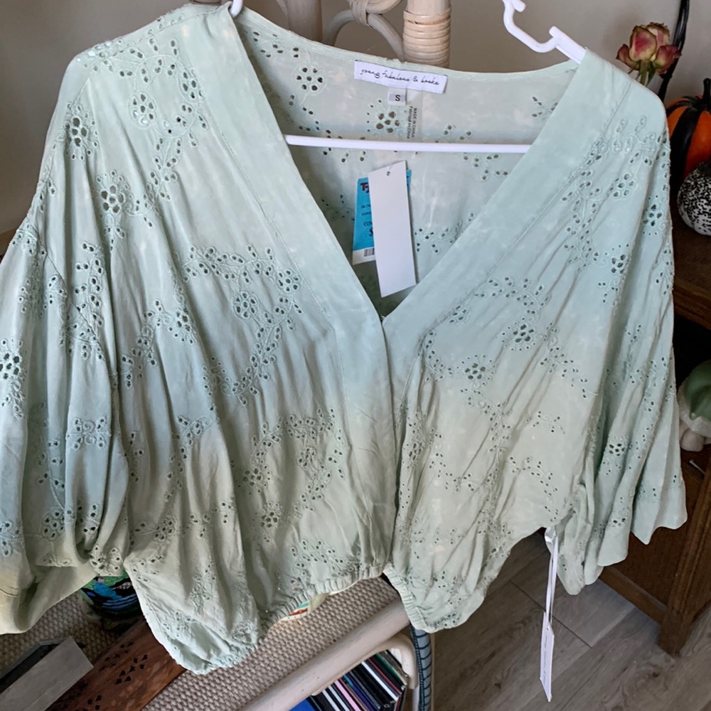 Mint colored top with floral pattern.